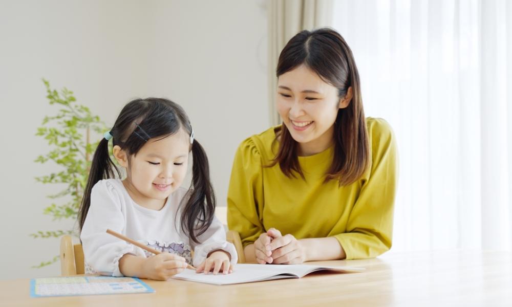 Mother and young girl doing homework