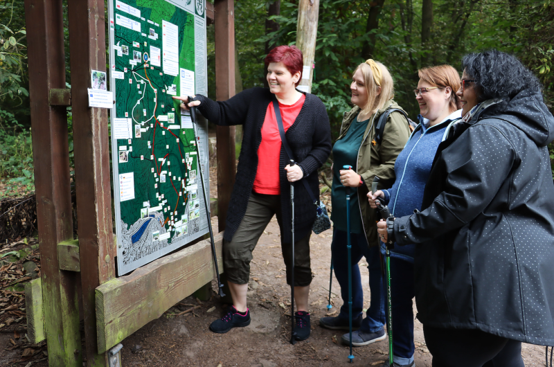 People standing looking at map of woodland