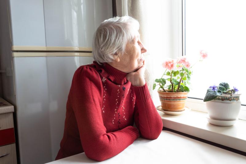 Older lady alone looking out of window