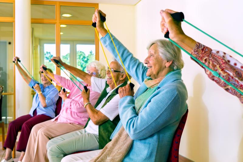 Older people exercising on chairs