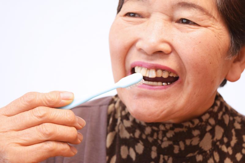 Older lady brushing teeth